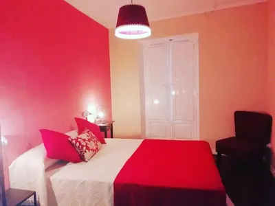 a red bedroom with a bed and a chair at Camino de Estrellas Mondoñedo Lugo in Mondoñedo
