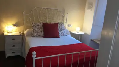 a bedroom with a bed with a red blanket and two night stands at Camino de Estrellas Mondoñedo Lugo in Mondoñedo
