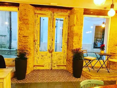 a yellow room with a wooden door and a table at Camino de Estrellas Mondoñedo Lugo in Mondoñedo