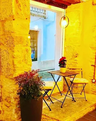 a patio with a table and chairs and a yellow wall at Camino de Estrellas Mondoñedo Lugo in Mondoñedo