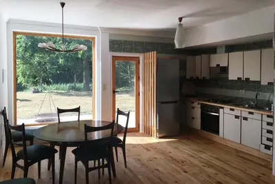 a kitchen with a table and chairs and a dining room at Finca BRIABÍ in La Cañiza