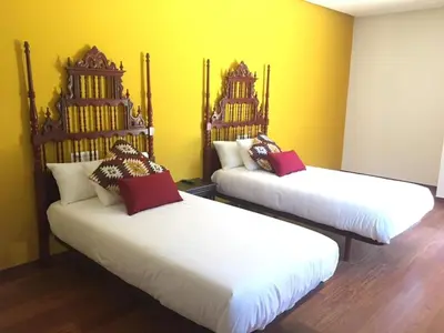 two beds in a room with yellow walls at Finca BRIABÍ in La Cañiza