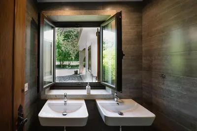 a bathroom with two sinks and a window at Finca BRIABÍ in La Cañiza