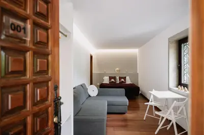 a living room with a couch and a bed at Finca BRIABÍ in La Cañiza