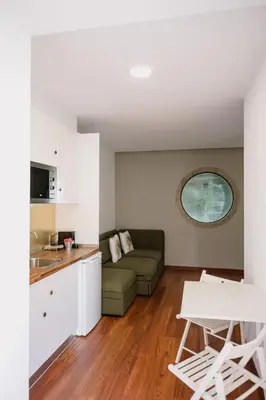 a living room with a couch and a kitchen at Finca BRIABÍ in La Cañiza