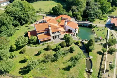 an aerial view of a large house with a river at Finca BRIABÍ in La Cañiza