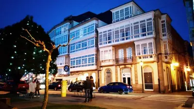 a large building on a city street at night at A&L Centro in Viveiro