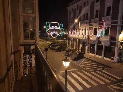a city street at night with neon signs at A&L Centro in Viveiro