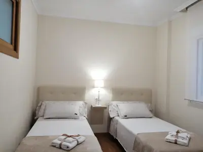 two beds in a small room with towels on them at A&L Centro in Viveiro