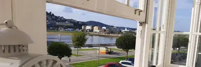 a window with a view of a river and buildings at A&L Centro in Viveiro