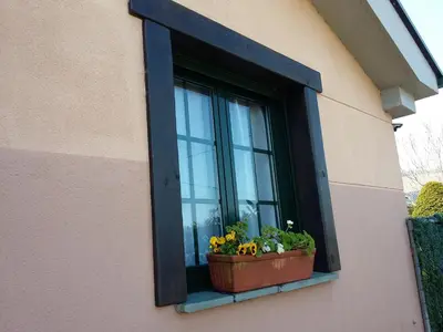 a window with a pot of flowers on a window sill at Casiña de Folgosa in Ribadeo