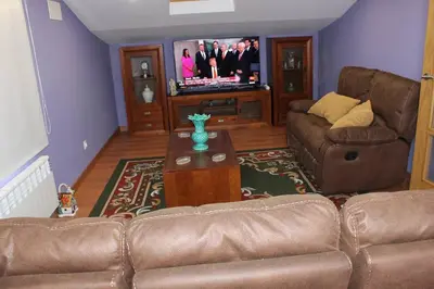 a living room with a couch and a tv at Casa Dana in Santiago de Compostela