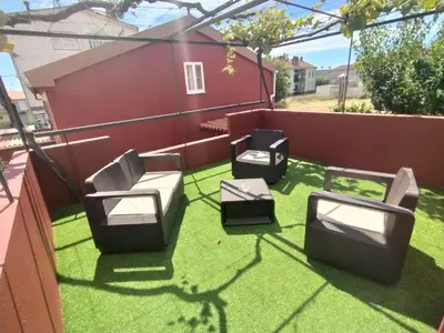 a patio with four chairs on the grass at Casa Dana in Santiago de Compostela