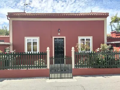 a small pink house with a black gate at Casa Dana in Santiago de Compostela