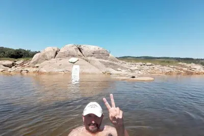 a man in the water giving the peace sign at Apartamento do Xurés in Maus de Salas
