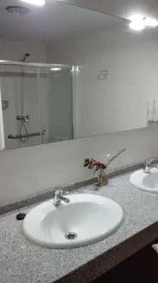 a bathroom with two sinks and a glass shower at Apartamento do Xurés in Maus de Salas