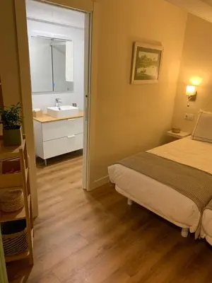 a bedroom with a bed and a bathroom with a sink at Casa Herreria in Caldas de Reis