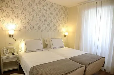 a bedroom with a large bed and a window at Casa Herreria in Caldas de Reis