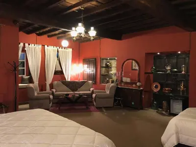 a bedroom with red walls and a bed and a living room at Pazo de Laia in Palas de Rei