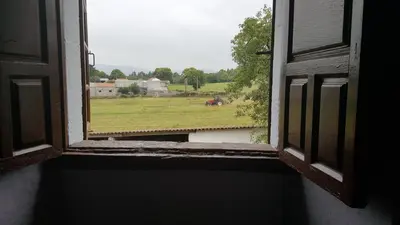 an open window with a view of a field at Pazo de Laia in Palas de Rei