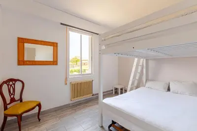 a bedroom with a bed and a chair and a window at Casa Mosteiro in Bribes
