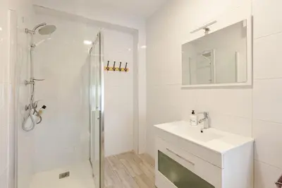 a white bathroom with a sink and a shower at Casa Mosteiro in Bribes