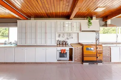 a kitchen with white cabinets and yellow appliances at Casa Mosteiro in Bribes
