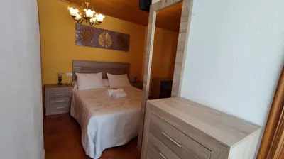 a small bedroom with a bed and a mirror at Casa David in Tríacastela