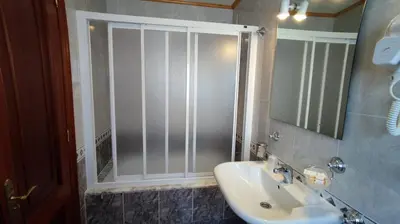 a bathroom with a shower and a sink and a mirror at Casa David in Tríacastela