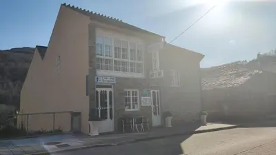 a building with chairs and tables in front of it at Casa David in Tríacastela