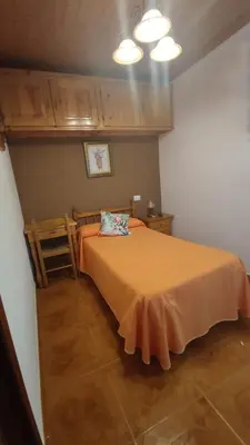 a bedroom with a bed with an orange bedspread at Casa David in Tríacastela