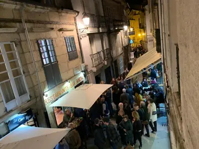 a crowd of people standing in an alley with umbrellas at Galerías 16 Viviendas Turísticas in Lugo