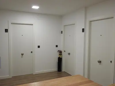 a room with three white doors with a guitar in it at Galerías 16 Viviendas Turísticas in Lugo