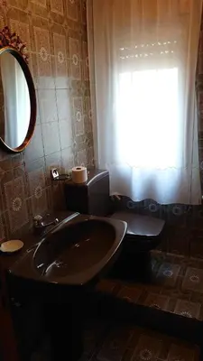 a bathroom with a sink and a toilet and a mirror at HOSTAL CAMELOT in Fabero