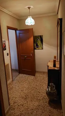 a hallway with a brown door and a table and a table sidx sidx at HOSTAL CAMELOT in Fabero
