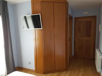 a room with a wooden cabinet and a lamp at HOSTAL CAMELOT in Fabero