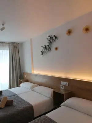 a hotel room with two beds and a window at PENSION ROSELLA in O Pedrouzo