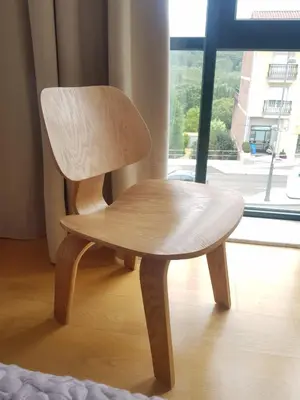 a wooden chair sitting in front of a window at PENSION ROSELLA in O Pedrouzo