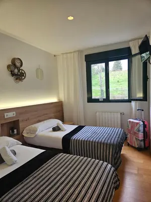 a hotel room with two beds and a window at PENSION ROSELLA in O Pedrouzo