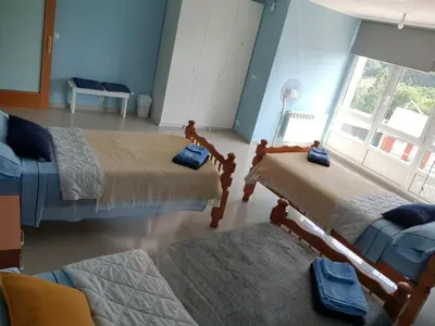 a room with two beds and a couch and a window at Estrella Do Camiño in Caldas de Reis