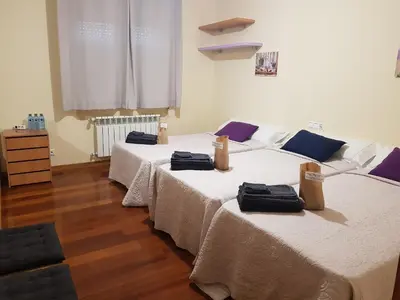 two beds sitting in a room with wooden floors at Estrella Do Camiño in Caldas de Reis
