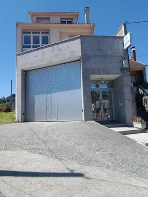a building with a garage door in front of it at Estrella Do Camiño in Caldas de Reis
