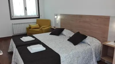 a hotel room with a bed and a chair at Hostel Boente in Boente