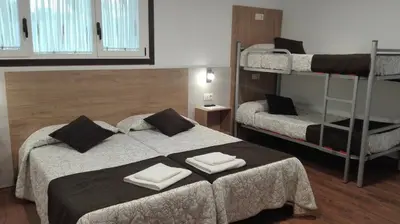 a bedroom with two beds and a bunk bed at Hostel Boente in Boente