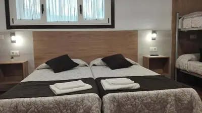 a bedroom with a large bed with two towels on it at Hostel Boente in Boente