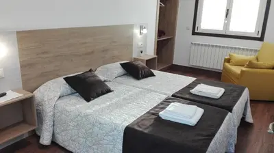 a room with three beds with towels on them at Hostel Boente in Boente