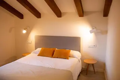 a bedroom with a bed with two orange pillows at Villa Lucerna Sports & Hotel Resort in Vigo de Sanabria