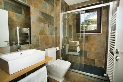 a bathroom with a toilet and a sink and a shower at Villa Lucerna Sports & Hotel Resort in Vigo de Sanabria