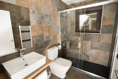 a bathroom with a toilet and a sink and a shower at Villa Lucerna Sports & Hotel Resort in Vigo de Sanabria