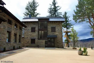 a large stone building with a balcony on it at Villa Lucerna Sports & Hotel Resort in Vigo de Sanabria